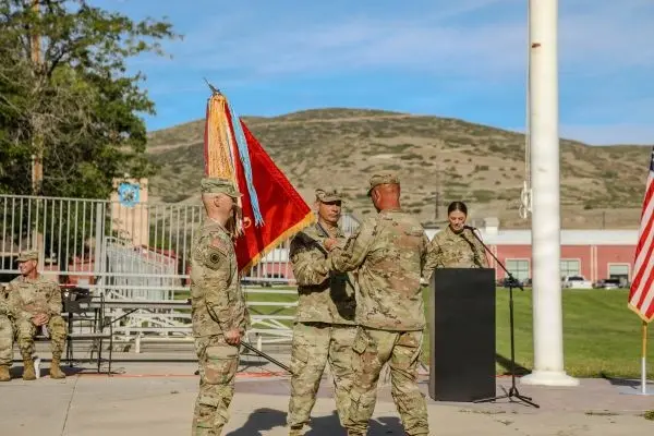 Military commanders passing the organizational colors during the 145th Field Artillery change of command ceremony