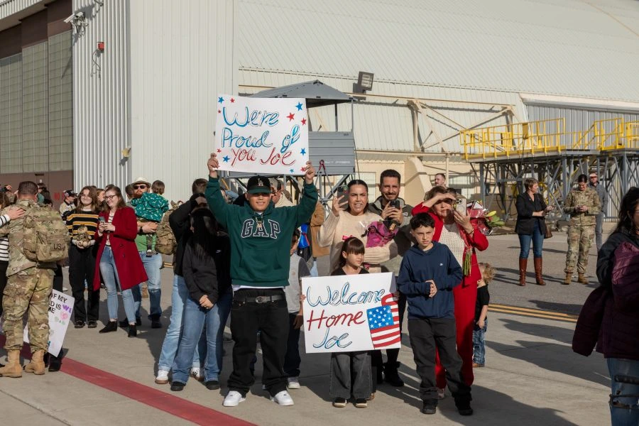 Family holding welcome home signs