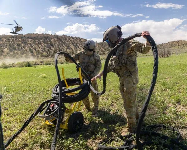 Two servicemembers wind cable
