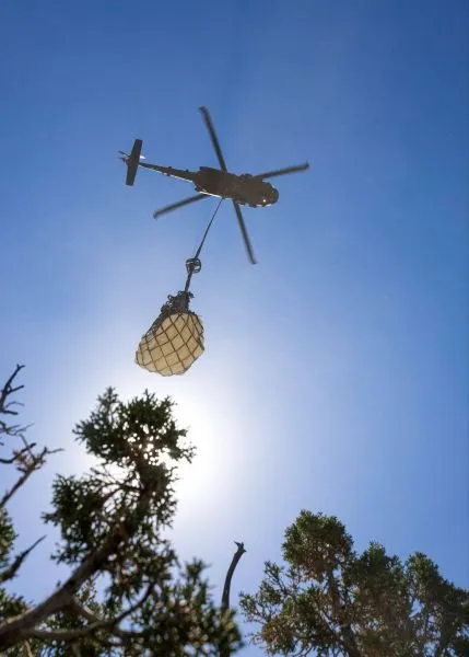 A helicopter carrying a large load by a cable