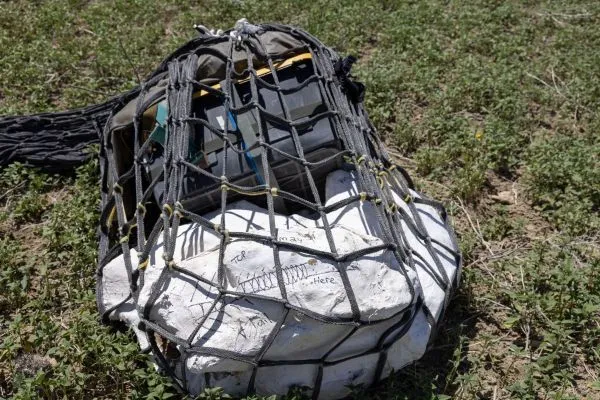 A rock and a hard plastic case in netting