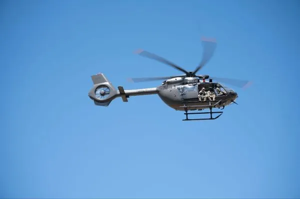 A helicopter flying in the sky with a photographer onboard