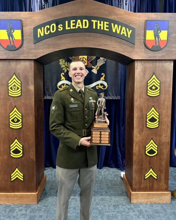 A soldier poses with a trophy following a competition