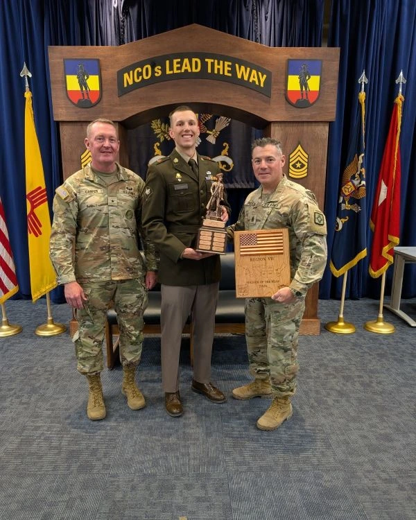 Three military members pose together following a competition