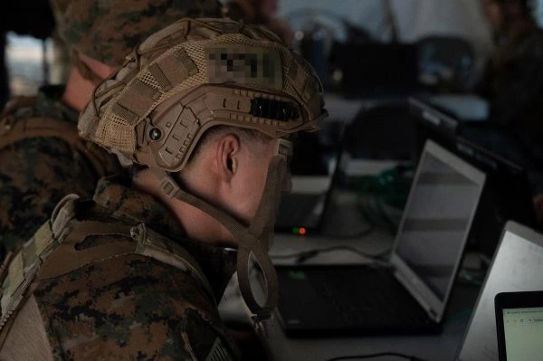 U.S. Marine Corps soldier, wearing a helmet, working on a computer, taking part in the Utah National Guard's Best Linguist Competition