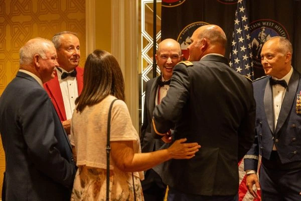 A group of individuals share a laugh at a formal event