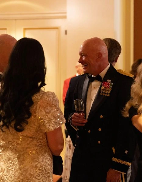 a military general converses with a couple at a formal event