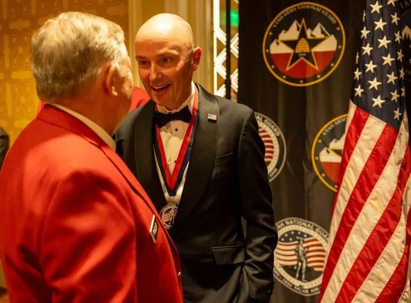 Two men greet one another at a formal event