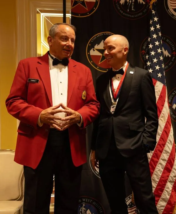 Two men share a moment of levity during a formal event