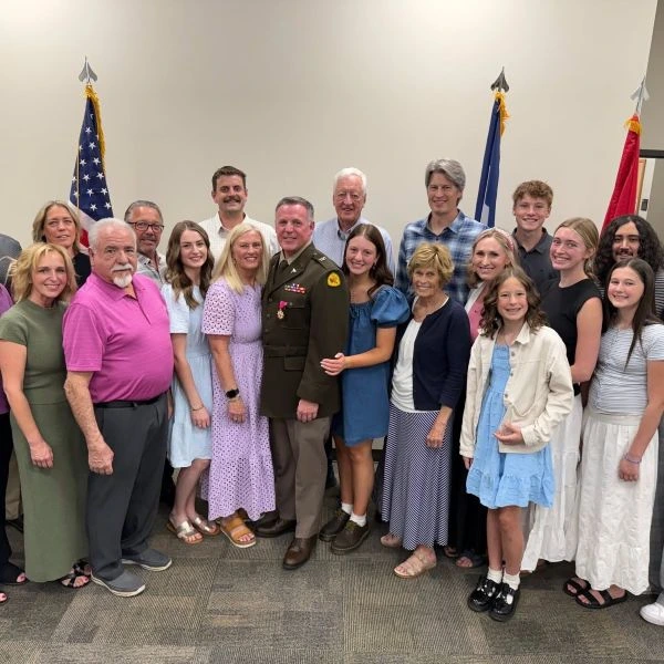 A servicemember poses with his family