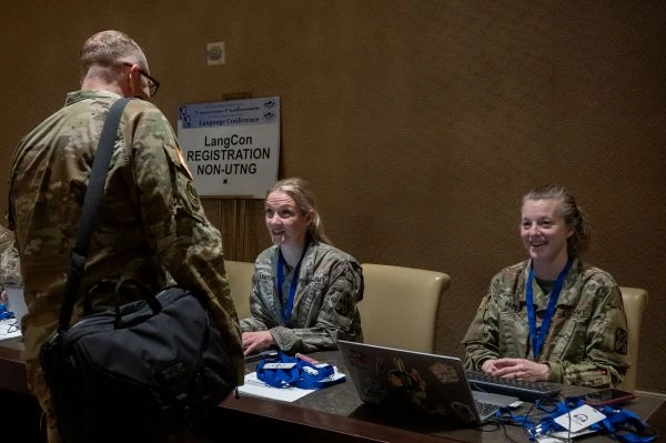 Two female soldiers sitting down talking to another soldier