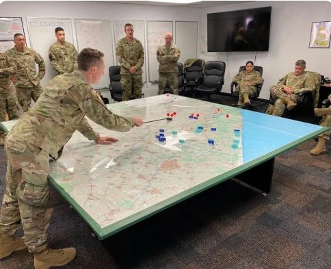 Servicemembers review a map in a classroom