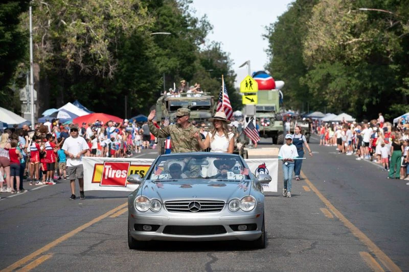 front view of soldier and wife riding in a car in 4th of July parade
