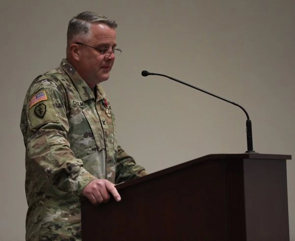 A soldier speaks at a podium