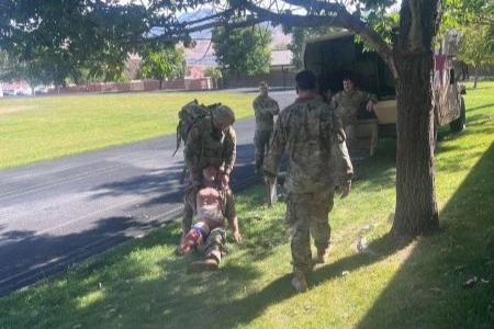 Soldiers dragging injured training dummy through grass