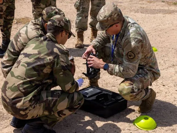 Soldiers crouched over a drone