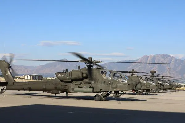 A line of helicopters parked on an airfield