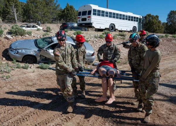 Servicemembers carry a medical mannequin on a stretcher