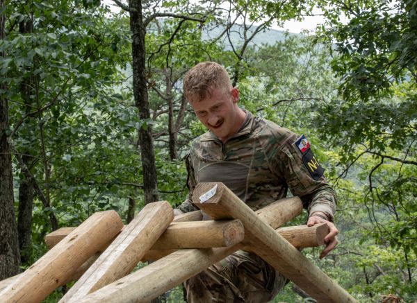 soldier carrying long wood
