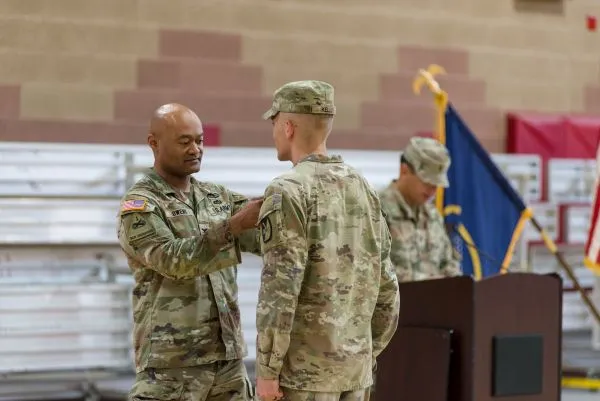 A high-ranking military official pins a medal on a Soldier