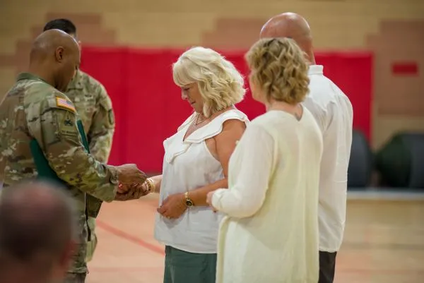 A high-ranking military official presents an award to a woman